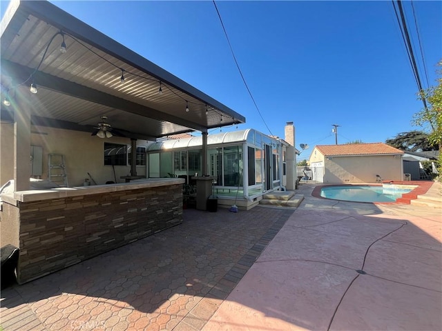 view of patio with a sunroom and ceiling fan