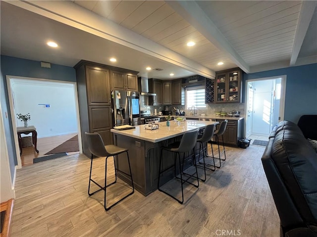 kitchen featuring sink, stainless steel appliances, light hardwood / wood-style floors, a breakfast bar, and a kitchen island