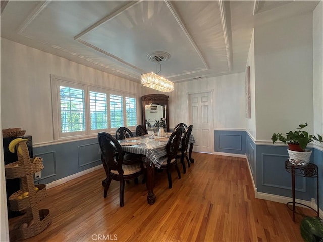 dining space featuring wood-type flooring and an inviting chandelier