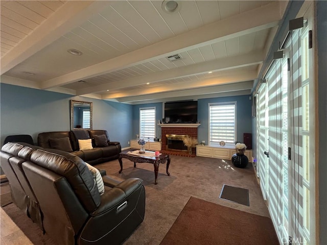 carpeted living room with beamed ceiling and a fireplace