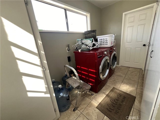 clothes washing area with washer and clothes dryer and light tile patterned floors