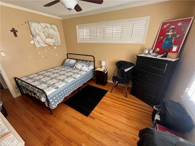 bedroom featuring hardwood / wood-style flooring, ceiling fan, and ornamental molding