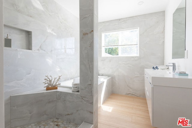 bathroom featuring vanity, wood-type flooring, and tile walls