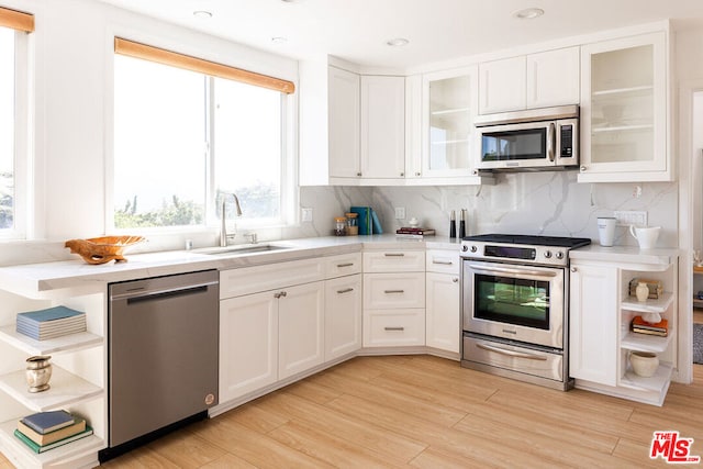 kitchen with white cabinets, stainless steel appliances, and a healthy amount of sunlight