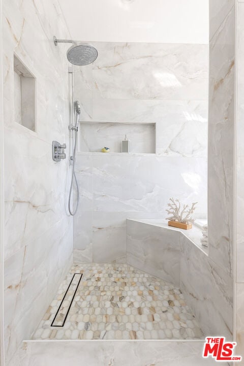 bathroom featuring a tile shower