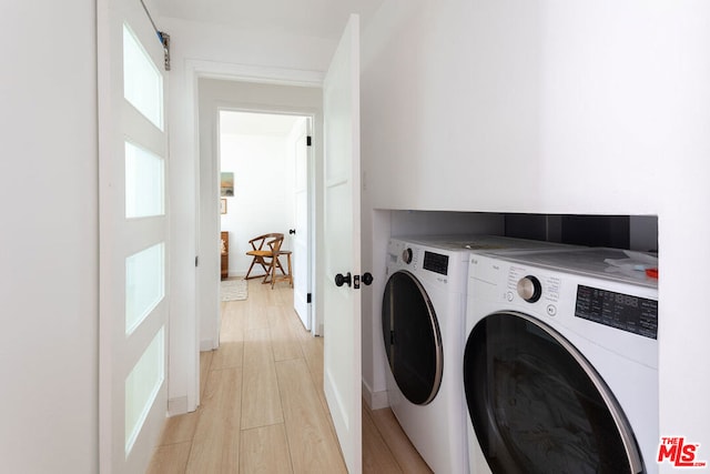 laundry area with separate washer and dryer and light hardwood / wood-style floors