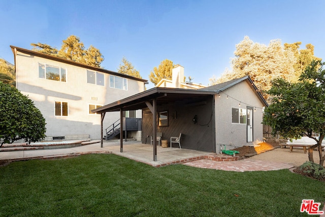 rear view of house featuring a yard and a patio area