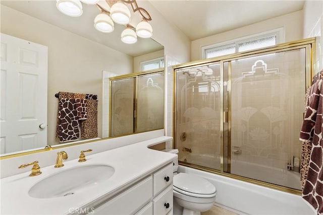 full bathroom featuring toilet, enclosed tub / shower combo, and vanity