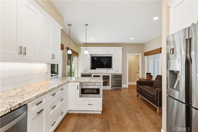 kitchen featuring kitchen peninsula, appliances with stainless steel finishes, wine cooler, and white cabinets