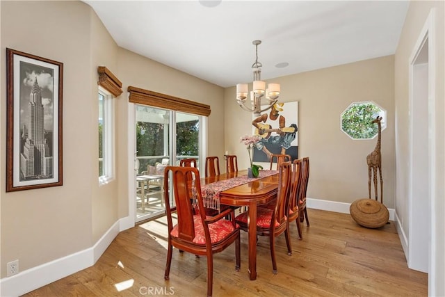 dining room featuring light wood-type flooring and an inviting chandelier