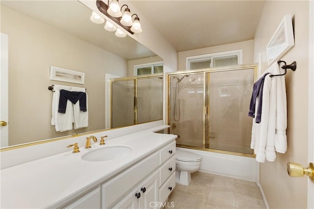 full bathroom featuring toilet, tile patterned flooring, enclosed tub / shower combo, and vanity