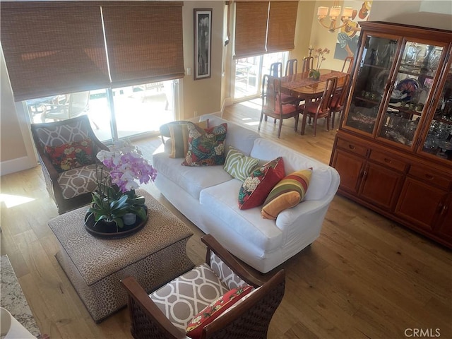 living room featuring light wood-type flooring and a chandelier