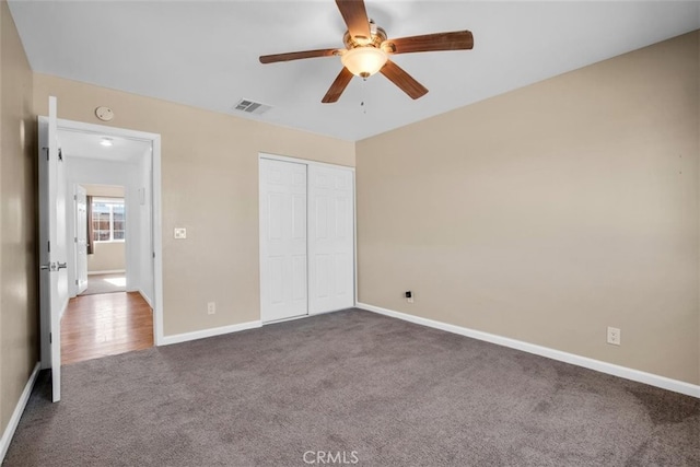 unfurnished bedroom with a closet, ceiling fan, and carpet floors