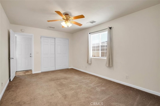 unfurnished bedroom featuring a closet, ceiling fan, and light colored carpet