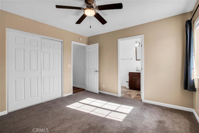 unfurnished bedroom with connected bathroom, light carpet, ceiling fan, and a closet