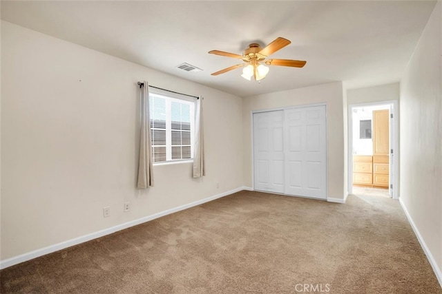 unfurnished bedroom with ceiling fan, a closet, and light carpet