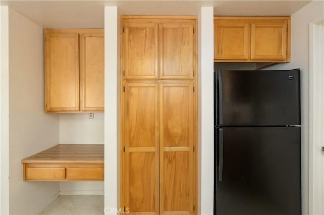 kitchen featuring black refrigerator and light brown cabinets