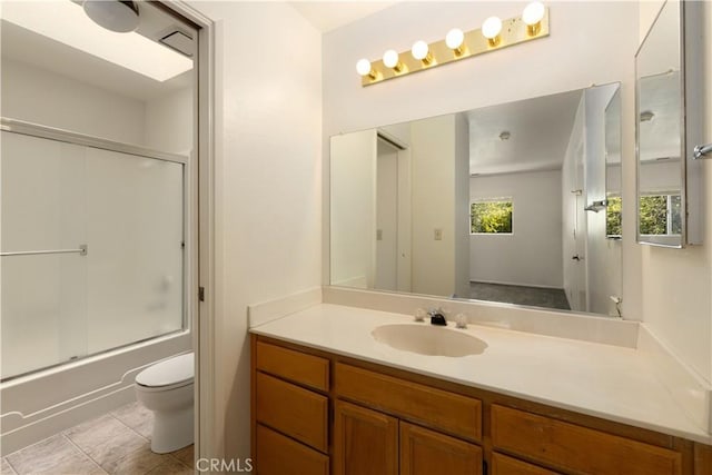 full bathroom with shower / bath combination with glass door, tile patterned floors, vanity, and toilet