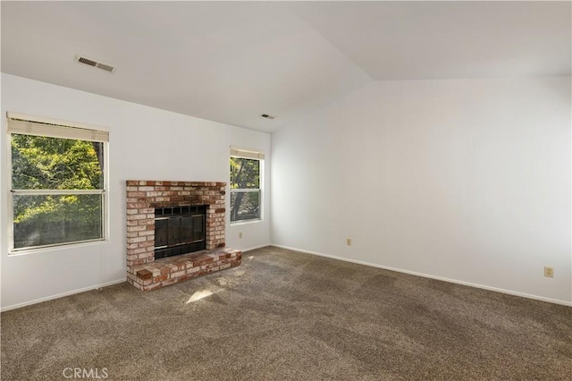 unfurnished living room featuring carpet, vaulted ceiling, and a brick fireplace