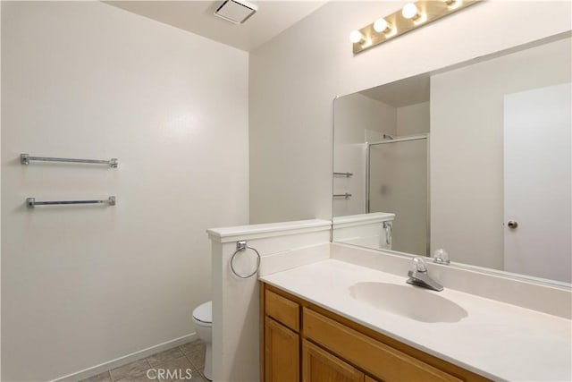 bathroom featuring tile patterned floors, vanity, toilet, and walk in shower