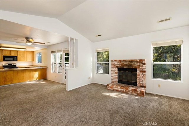 unfurnished living room featuring a fireplace, carpet floors, vaulted ceiling, and ceiling fan