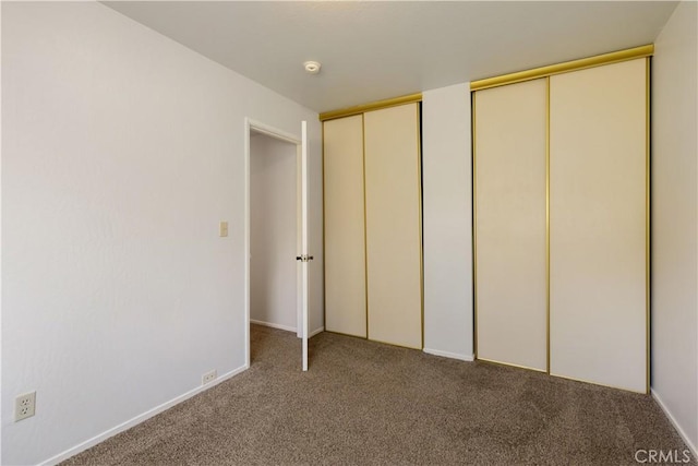 unfurnished bedroom with light colored carpet and two closets