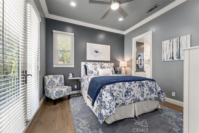 bedroom with ornamental molding, hardwood / wood-style floors, ensuite bathroom, and ceiling fan