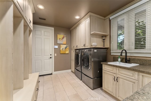 laundry area featuring independent washer and dryer, cabinets, and sink