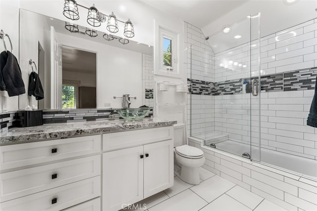 full bathroom featuring vanity, toilet, a healthy amount of sunlight, and tile patterned flooring