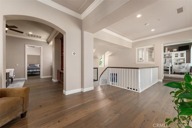 corridor with dark wood-type flooring and crown molding