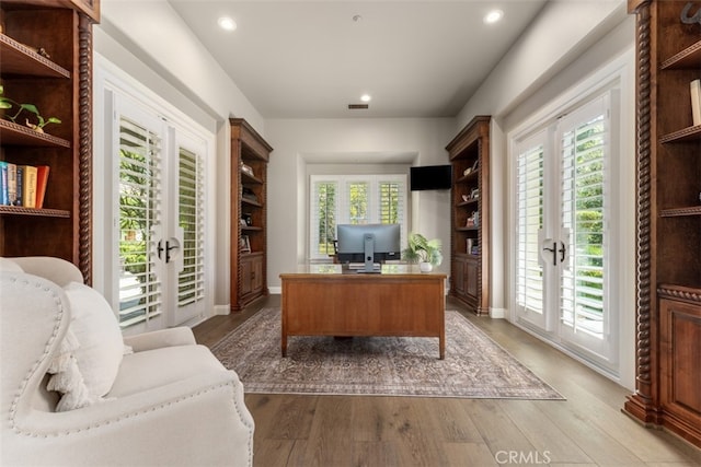 office area featuring french doors, a healthy amount of sunlight, and wood-type flooring