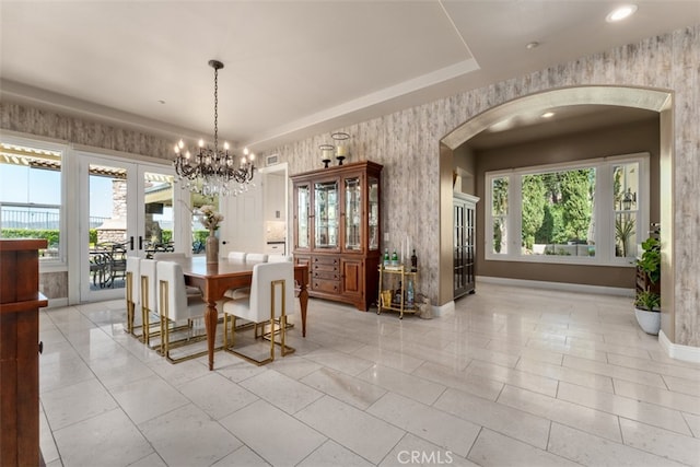 tiled dining room with a chandelier and a healthy amount of sunlight