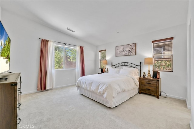 bedroom with lofted ceiling and light colored carpet