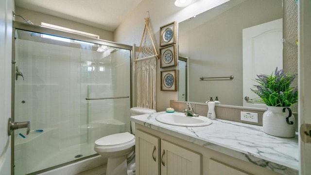 bathroom featuring toilet, vanity, and an enclosed shower