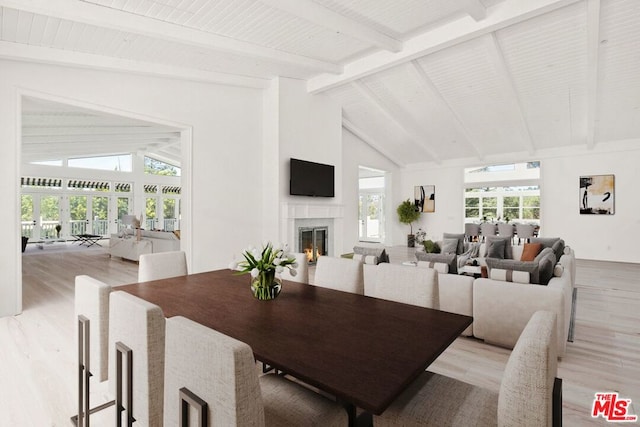 dining area with beam ceiling, plenty of natural light, and light hardwood / wood-style flooring