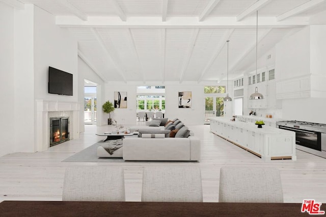 living room featuring beamed ceiling, light hardwood / wood-style floors, and high vaulted ceiling