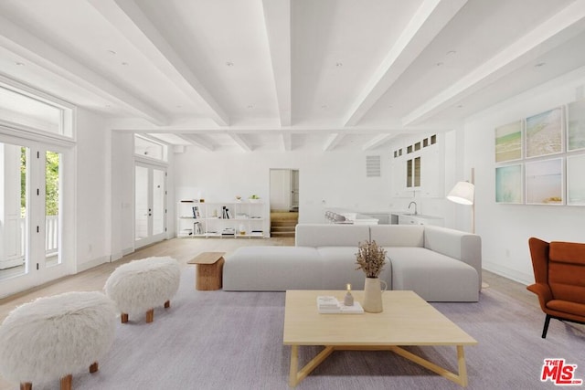 living room featuring beam ceiling and french doors