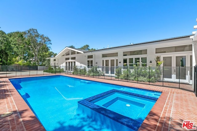 view of pool with an in ground hot tub and french doors