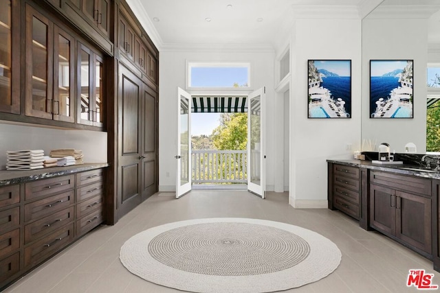 entryway featuring light tile patterned floors, a healthy amount of sunlight, and ornamental molding