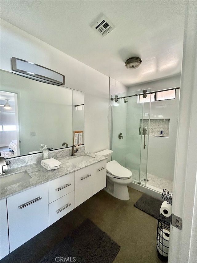 bathroom with walk in shower, vanity, and toilet