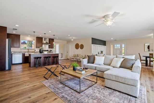 living room with light wood-type flooring and ceiling fan