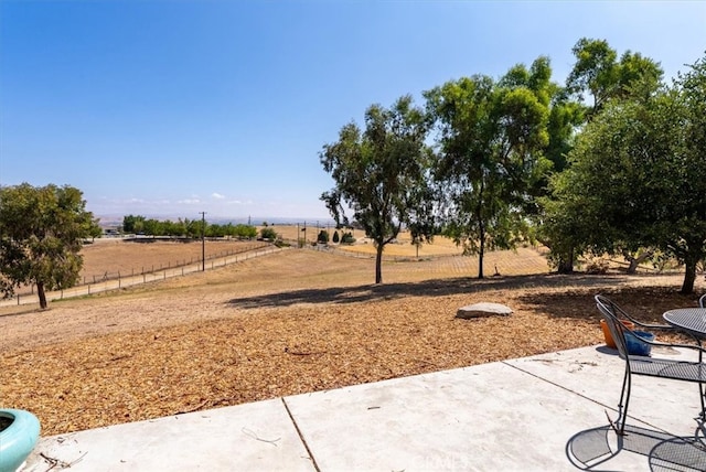 view of yard with a rural view and a patio area