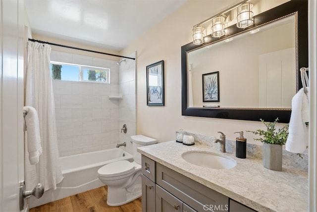 full bathroom with toilet, hardwood / wood-style flooring, vanity, and shower / tub combo