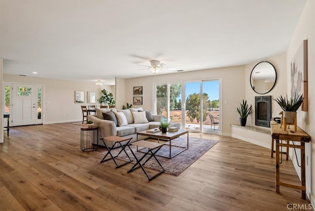 living room with wood-type flooring and ceiling fan