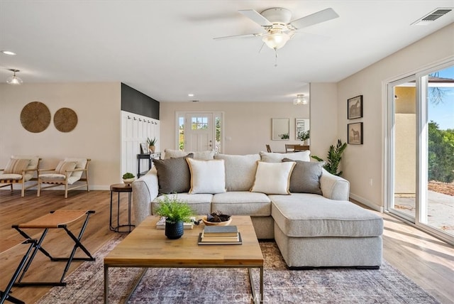 living room featuring light hardwood / wood-style flooring and ceiling fan