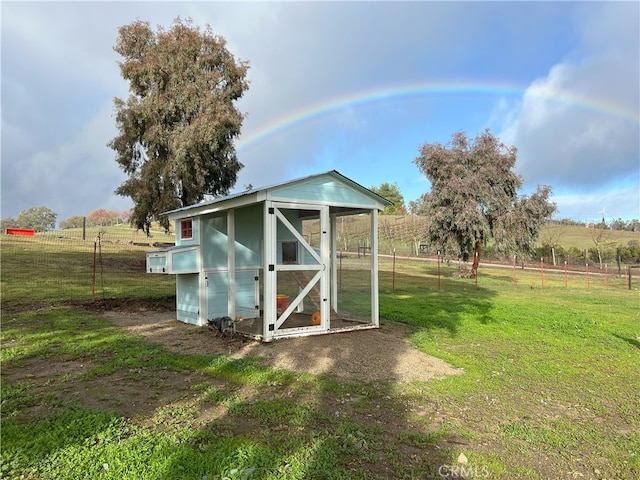 view of outdoor structure with a lawn and a rural view