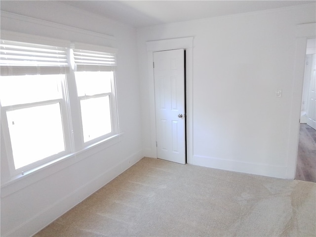 unfurnished room featuring light carpet