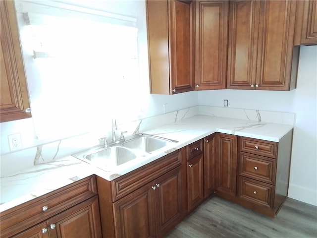 kitchen featuring light stone countertops, sink, and light hardwood / wood-style flooring