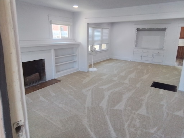 unfurnished living room featuring light carpet