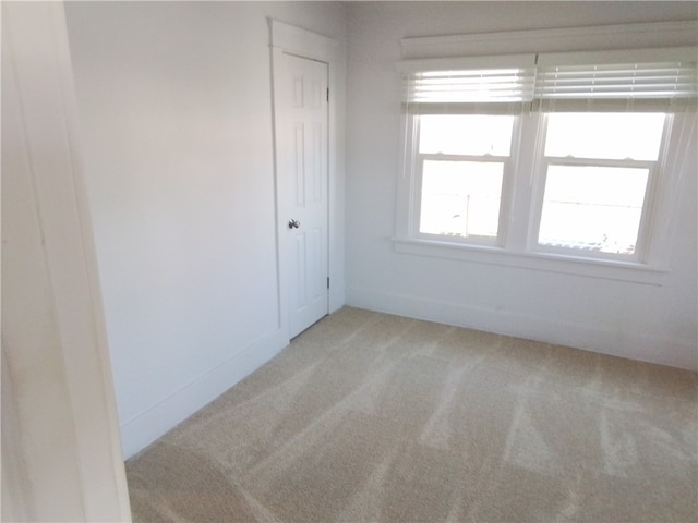 unfurnished room featuring light carpet